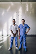 © Maskot - Portrait of multiracial male medical professionals standing in front of wall at hospital