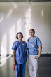 © Maskot - Portrait of senior female doctor standing with young trainee in front of wall at hospital