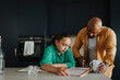 © Maskot - Father helping daughter in studies while holding coffee cup at home