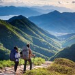 © 貴宏 西山 - A young couple with backpacks hiking on a mountain trail, overlooking a stunning valley belo