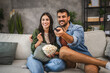 © Miljan Živković - adult couple watch movie, series on television and eat popcorn at home