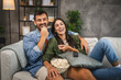 © Miljan Živković - adult couple watch movie, series on television and eat popcorn at home