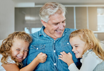 Wall Mural - Happy, grandfather and relax with children at house for family bonding, love and embrace of support together. Excited, senior man and girl with hug for security, trust and comic joke in living room