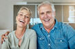 © Maass/peopleimages.com - Retirement, laugh and couple in lounge for relax, together and love in living room or home. Happy man, woman and joke or humor in house for support trust and communication for health and wellness