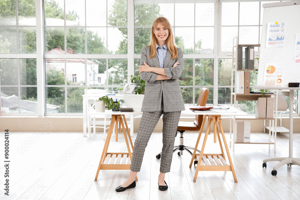 Young female accountant near workplace in office