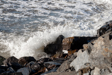 Close-up photo of wave breaking on rocks.