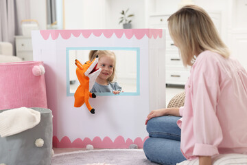 Poster - Puppet theatre. Smiling girl performing show with toy to her mother at home