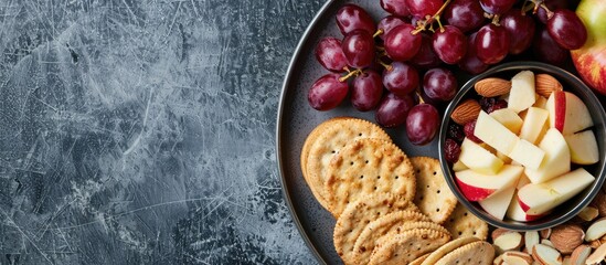 Aufkleber - Assorted healthy snack options including apples red grapes almonds cranberries Swiss cheese and crackers on a plate with copy space image
