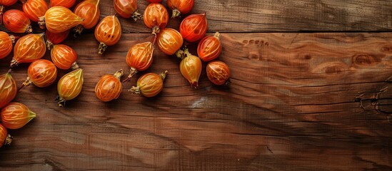 Leinwandbilder - Overhead shot of cape gooseberries on a wooden surface with space for additional images