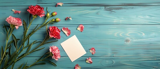 Poster - Mother s Day photography concept featuring lovely carnations on a template card placed on a bright wooden table with copy space image available captured from a flat lay top view for a mock up