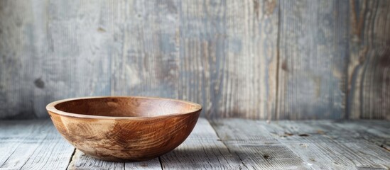Leinwandbilder - Rustic brown wooden bowl displayed on a gray wooden table with a simple classic look ideal for a copy space image