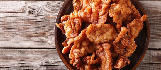 Poster - Crunchy fried pork cracklings displayed on a wooden surface with room for text in the image. with copy space image. Place for adding text or design