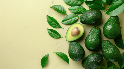 group of green avocados with leaves on a beige background with copy space.