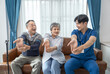 © Verin - a young male assistant in uniform advice and help asian senior couple arm stretch exercise in the room,health care worker nurse visit at patient home,concept of elderly care,home care