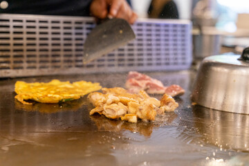 The chef is stirring the delicious Teppanyaki chicken and the aroma is overwhelming