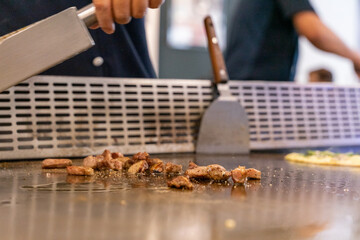 The chef is stirring the delicious Teppanyaki chicken and the aroma is overwhelming