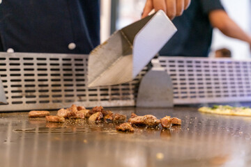 The chef is stirring the delicious Teppanyaki chicken and the aroma is overwhelming