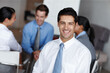 © Leffy/peopleimages.com - Portrait, smile and business man in office for coworking, career or job at workplace. Face, confident entrepreneur or professional investment manager, employee or worker with team planning at meeting