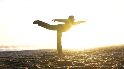 Wall Mural - Woman doing pilates on the beautiful black sand beach of Reynisfjara in Iceland in winter