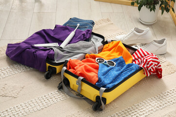 Wall Mural - Open suitcase with traveler's belongings on floor