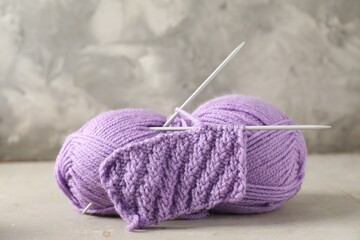 Poster - Skein of yarn, knitting needles and pattern sample on light textured table, closeup