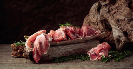 Wall Mural - Italian prosciutto crudo or Spanish jamon with rosemary.