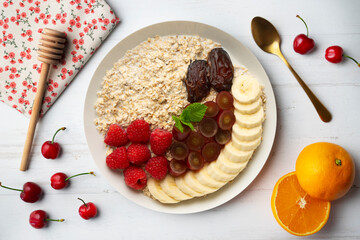 Canvas Print - Delicious and healthy bowl of oatmeal with raspberries, dates, grapes and banana.