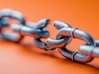 © auc - broken metal chain link on orange background - symbol of weakness, vulnerability, and disconnection