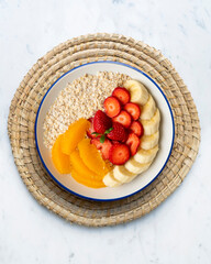 Canvas Print - Delicious and healthy bowl of oatmeal with orange, strawberry and banana.