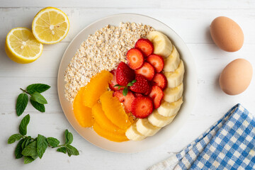 Canvas Print - Delicious and healthy bowl of oatmeal with orange, strawberry and banana.