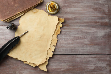 Sticker - Sheet of old parchment paper, black feather, inkwell, vintage book and candle on wooden table, flat lay. Space for text