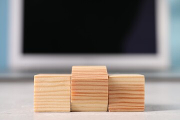 Sticker - Wooden cubes on light table against blurred background