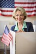 © Tekin - A mature woman, out of focus in the background, is voting in a voting booth to elect the President of the United States. A small US flag decorates the voting area in the foreground