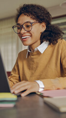 Wall Mural - Smiling female manager working remotely on laptop from home while sitting at living room