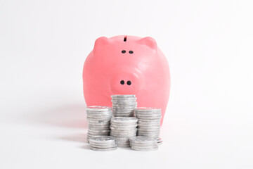 Pink piggy bank and stack of coins isolated on white background. Investment budget savings wealth business retirement, finance, money, banking concept. copy space