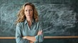 © Chimpanzky  - angry and disappointed female teacher standing in front of a blackboard with her hands folded