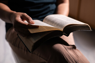 Poster - Woman of faith holds the Bible in her hand, believing deeply in the teachings of Jesus Christ and the presence of God, embodying her Christian religion. bible, person, hand, religion, book, faith.