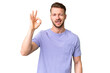 © luismolinero - Young handsome caucasian man over isolated chroma key background showing ok sign with fingers