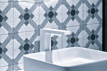 Poster - A white sink with a blue tile wall behind it. The tile pattern is a mix of squares and circles. modern bathroom interior
