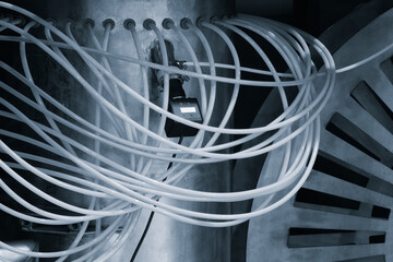 Poster - A wire is wrapped around a pipe and has a black object in the middle Industrial background concept