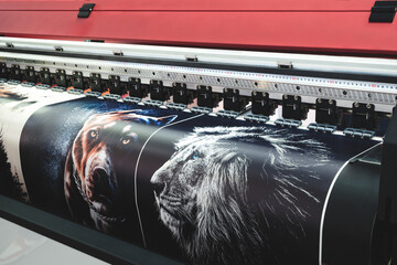 Poster - A large printer is printing a series of images, including a dog and a lion. The printer is black and red, and the images are colorful and detailed. modern technology concept background