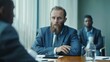 © Zaleman - Photograph of a bearded man sitting behind a conference table in a conference room discussing finances with an African businessman