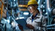 © Rossarin - A female engineer in a hard hat and safety glasses reviews data on a tablet in an industrial environment.