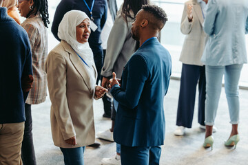 Wall Mural - networking event with diverse professionals engaging in conversation during a business conference