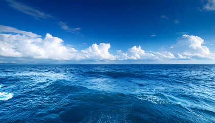 Wall Mural - Under a vibrant blue sky with clouds a marine waves ocean background.