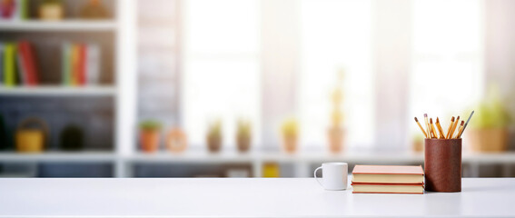 Poster - White desk with books, paintbrushes, and a coffee cup in a modern office and blurred bookshelf background