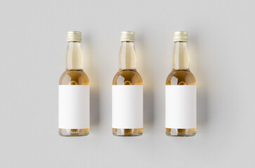 Wall Mural - Miniature spirits, liquor bottle mockup. Clear glass, amber liquid with a blank label.