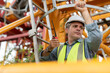 © Supachai - Asian male engineer wearing safety vests and helmet climbing metal ladder inspection and maintenance tower crane at construction site.