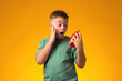 © Aleksej - Surprised child boy holding alarm clock over yellow background. Time management concept