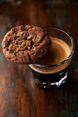 Wall Mural - Chocolate cookie and Coffee in glass cup on rustic wooden background. Close up.	